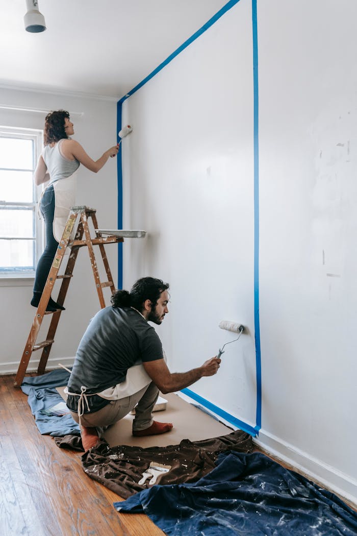 services-03 Couple working together on room painting project with rollers. Perfect for home improvement themes.